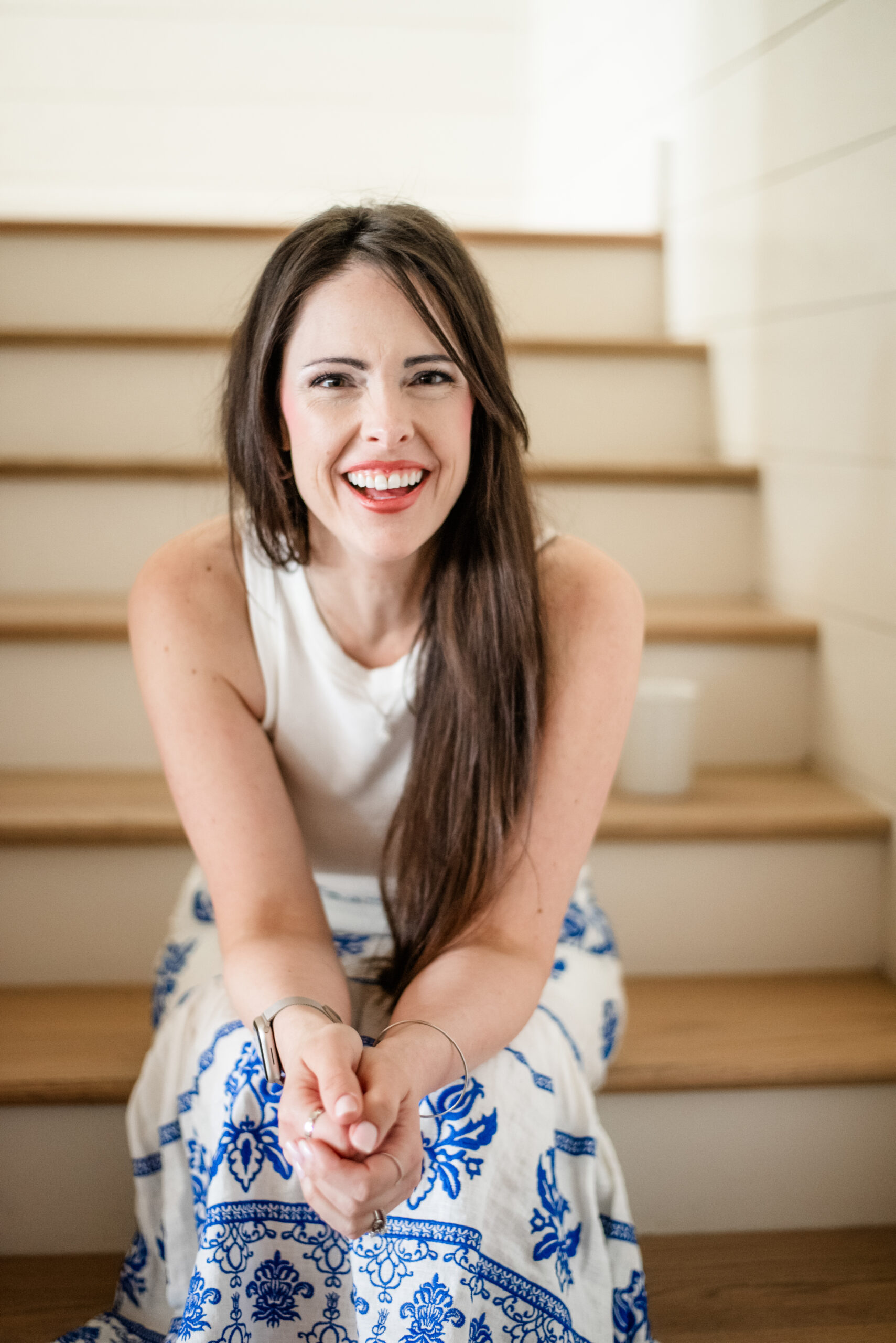 Angela laughing on the stairs of a beach house